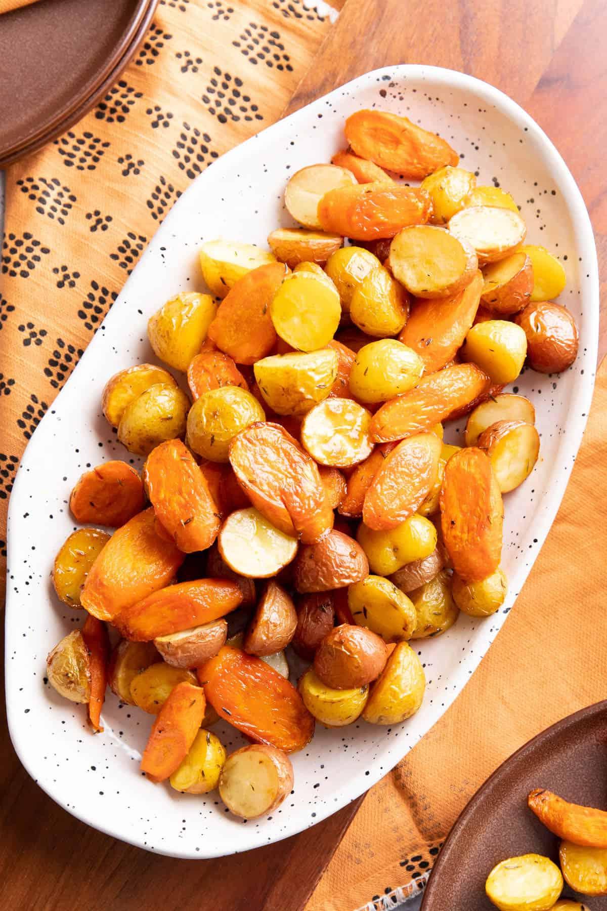 Teller mit gerösteten Kartoffeln und Karotten