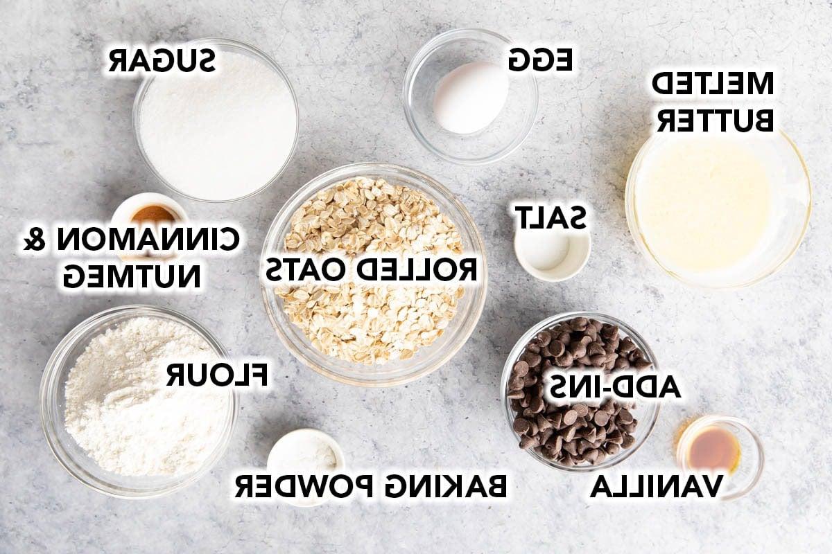 Zutaten für knusprige, zähe Haferkekse – Mehl, Haferflocken, Backpulver, gemahlener Zimt, gemahlene Muskatnuss, Salz, Butter, Zucker, Ei, Vanille, optionale Zugaben wie Schokostückchen.