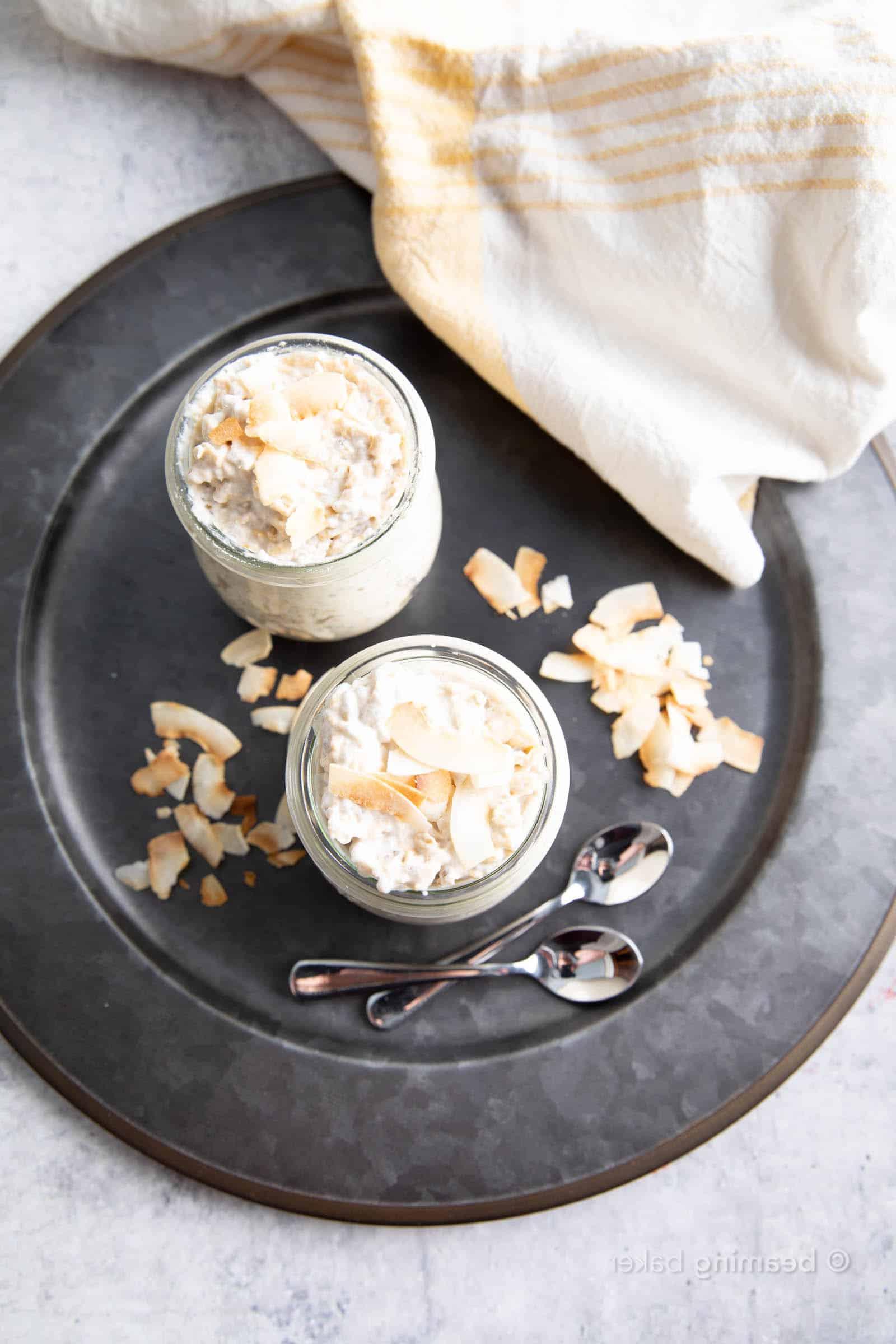 Blick von oben auf Kokos Overnight Oats auf einem Serviertablett mit gerösteten Kokosraspeln