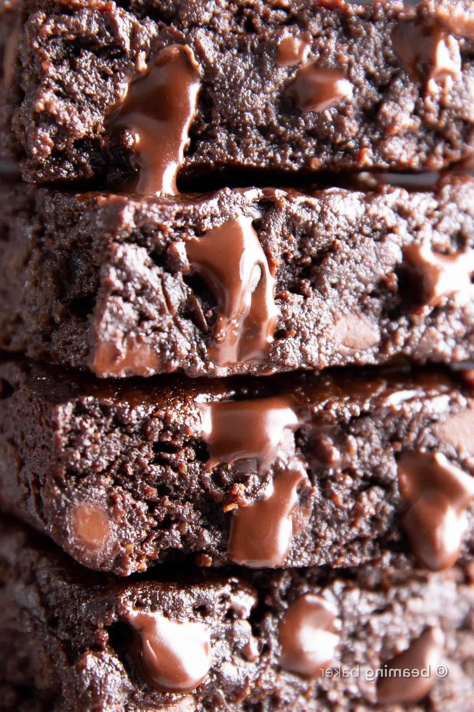 Super-Nahaufnahme von schmelzenden veganen Schokoladenstückchen auf einem Stapel veganer glutenfreier Brownies