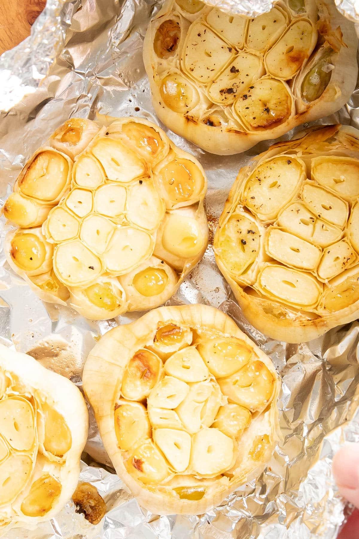 Zwei Fotos, die zeigen, wie man geröstetes Knoblauchbrot zubereitet – den Knoblauch rösten