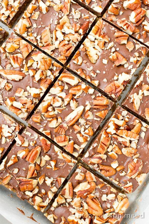 Paleo-Schoko-Pekan-Riegel ohne Backen (V, GF, Paleo): Ein 5-Zutaten-Rezept für köstliche Pekanriegel, bedeckt mit einer dicken Schicht Schokolade und Nüssen. #Paleo #Vegan #GlutenFrei #MilchFrei | BeamingBaker.com