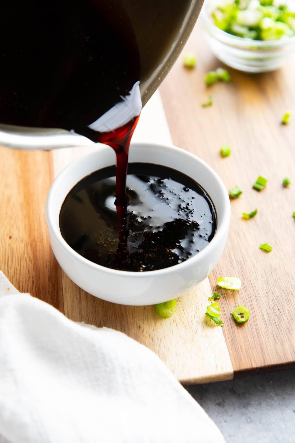 Gießen des japanischen Unagi-Soßen-Rezepts aus dem Topf in eine Servierschale.
