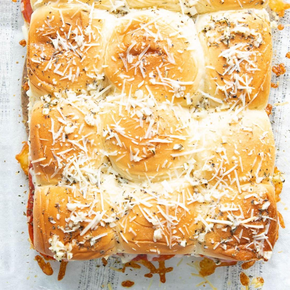 Nahaufnahme von Parmesan, Butter, Knoblauch und Gewürzen, die auf die obere Schicht dieses italienischen Rezepts gebacken wurden